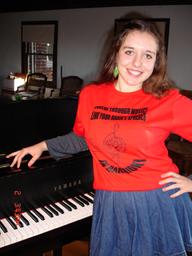 Young soprano singer CHARLOTTE KHUNER (16 y.o.), after rehearsal for the upcoming NAMM Show performance in LA, CA, USA; by her piano in t-shirt with the advocacy for music education through brain research message for the for the int'l campaign  http://www.youtube.com/watch?v=rLtLBIxMYgo